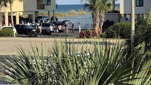 Un immeuble à plusieurs étages doté de balcons, d’un parking et offrant une vue sur la mer.