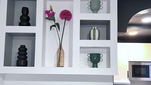 Una cocina con muebles blancos, un microondas y un horno empotrado.