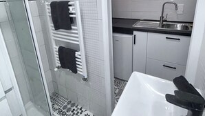 Un baño con ducha, lavamanos e inodoro.