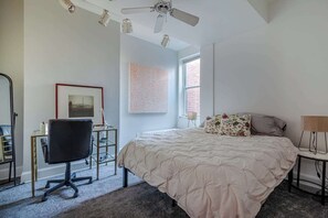 A bedroom with a bed, a desk, a chair, a ceiling fan, and a window. - Downtown Victorian home w/Stunning Roof & Parking (Washington)