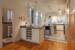 A modern kitchen with a central island, pendant lighting, and a view to the dining area. - Downtown Victorian home w/Stunning Roof & Parking (Washington)