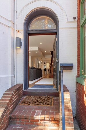An entrance with a brick pathway leading to a modern interior. - Downtown Victorian home w/Stunning Roof & Parking (Washington)