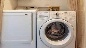 Een voorlader wasmachine en droger staan naast elkaar in een wasserij.