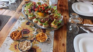 Mesa de comedor dispuesta con platos, cubiertos y una bandeja de aperitivos.