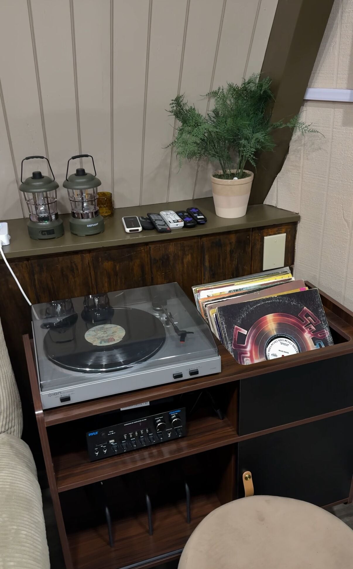 Un pupitre en bois pour partitions, équipé d’une platine tournante, d’un lecteur de disques et d’une collection de vinyles.