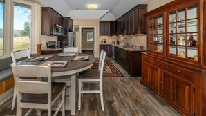 A kitchen with dark wooden cabinets, a central island, and a built-in wine cabinet. - Riverfront country setting (Bath County)