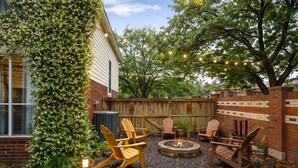 A backyard with a fire pit, wooden chairs, and a brick wall. - Luxurious 6-bedroom house with pool, grand piano and massage chair in Houston (Houston)
