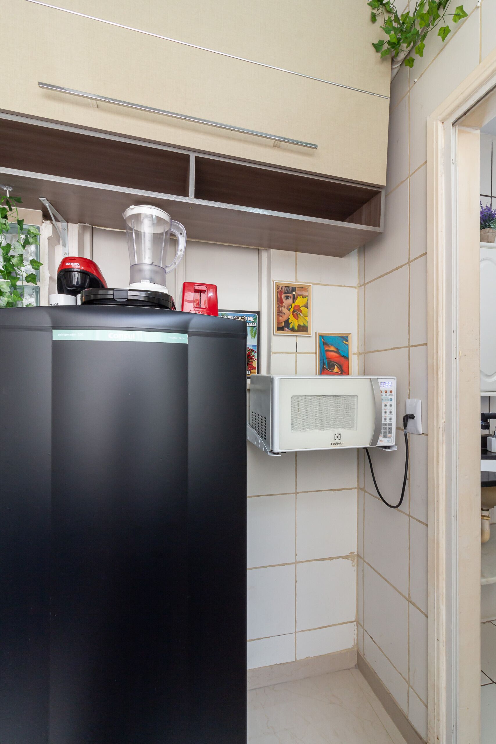 A kitchen with a black countertop, a microwave, and a blender.