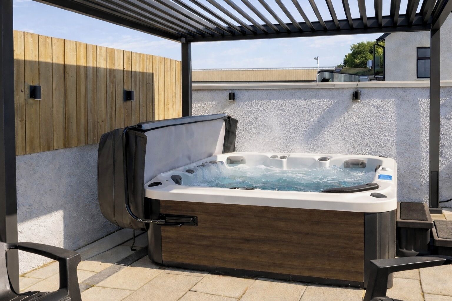 A hot tub in an outdoor setting with a pergola overhead.
