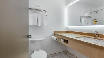 Ein modernes Badezimmer mit Toilette, Waschbecken, Spiegel und Handtuchhalter.