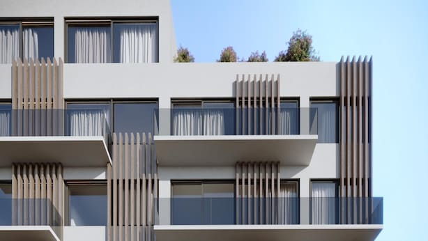 A modern multi-story building with balconies and large windows.