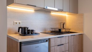 A modern kitchen with a built-in dishwasher, a coffee maker, and a kettle.
