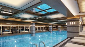 A large indoor swimming pool with a glass ceiling, lounge chairs, and exercise equipment. - Best Western Premier Imperial Dalat (Lam Vien - Da Lat)