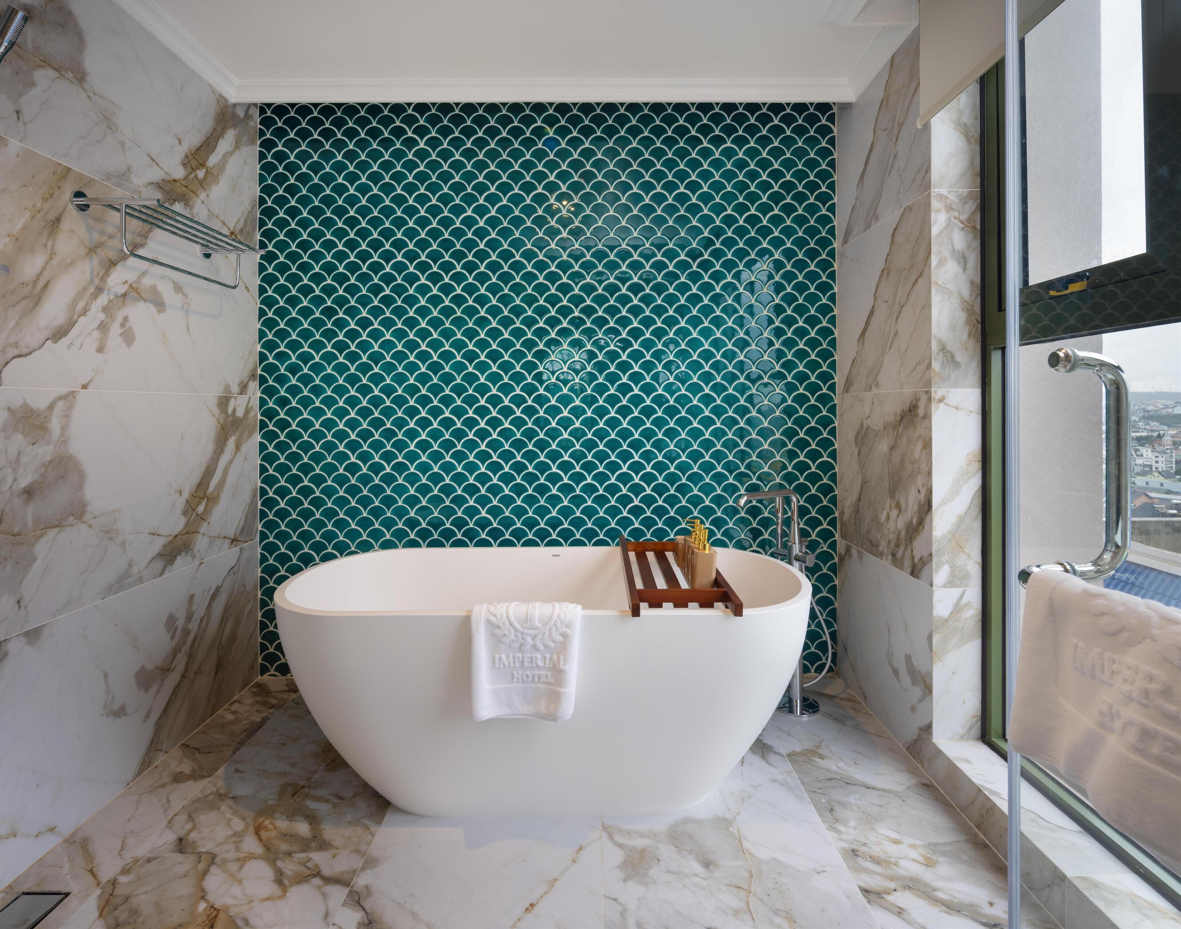 Ein Badezimmer mit freistehender Badewanne, einem Handtuchhalter und einer Duschkabine.