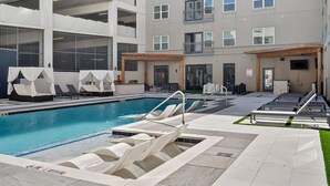 A modern indoor pool area with multiple lounge chairs and a pool. - Worldcup Ready Stylish 1BR in West Village  Pool + Free Parking (Dallas)