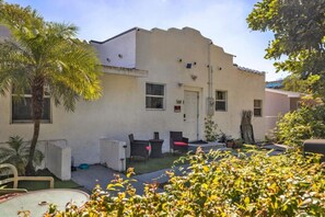 A building with a flat roof, a door, and windows. There are outdoor chairs and a table. - Suarez Art Stay, Buena Vista, Sleeps 10, Park (Miami)