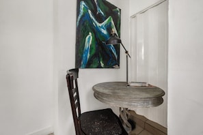 A corner room with a round table, a chair, a floor lamp, and a painting on the wall. - Suarez Art Stay, Buena Vista, Sleeps 10, Park (Miami)