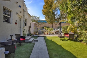 Une cour avec des sièges extérieurs, un chemin et un bâtiment portant un numéro.