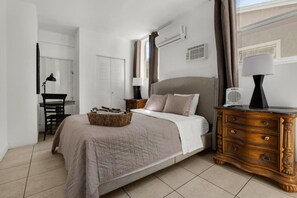 A bedroom with a bed, dresser, and a desk with a chair. - Suarez Art Stay, Buena Vista, Sleeps 10, Park (Miami)