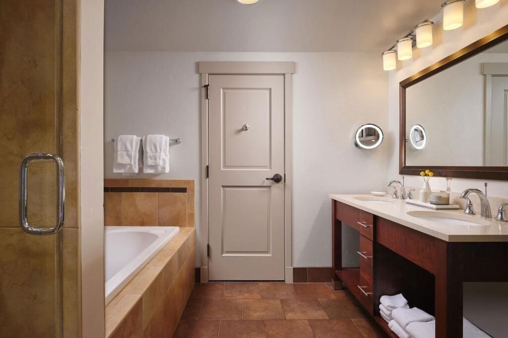 Un baño con bañera, tocador con espejo y una puerta.
