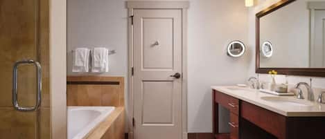 Un baño con bañera, tocador con espejo y una puerta.
