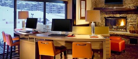 Una cocina moderna con una isla central, taburetes de bar, una chimenea y un ventanal con vistas a un paisaje nevado.