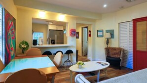 A compact living space with a dining area, a kitchenette, and a seating area with a small table and chairs. - Suarez Art Stay, 3BR Miami Oasis with Parking (Miami)