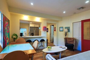 A compact living space with a dining area, a kitchenette, and a seating area with a small table and chairs. - Suarez Art Stay, 3BR Miami Oasis with Parking (Miami)