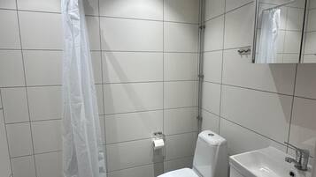 Standaard tweepersoonskamer | Badkamer | Een douche, een haardroger, handdoeken, zeep