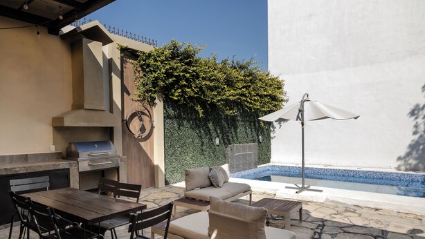 An outdoor patio with a grill, dining table, and lounge area. - Residence with swimming pool and large patio for families (Monterrey)