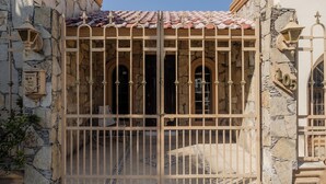 A gated entrance with stone walls and a tiled roof. - Residence with swimming pool and large patio for families (Monterrey)