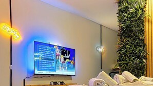 Una camera da letto moderna con un letto, una TV a parete e un giardino verticale.