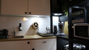 Una cucina con lavello, bilancia, macchina da caffè e forno a microonde.