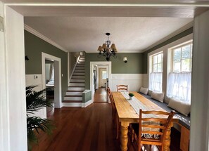 A dining area with a wooden table and chairs, a chandelier, and a staircase leading to another room. - Charming cottage near the Wilcox & Historic Downtown. 4 Bedrooms (Aiken)