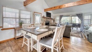A spacious living area with a dining table, chairs, and a fireplace. - Steps to Shooting Creek (Hayesville)