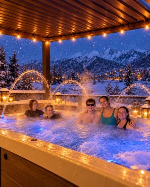 A hot tub with a snowy mountain backdrop, surrounded by wooden structures and string lights. - Magical Retreat: Private Swim Spa-Hot Tub• Fire Pits•Romantic Escape• Family Fun (Salem)