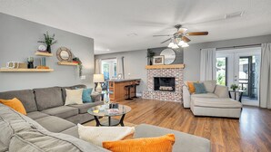 A living room with a fireplace, a sofa, a coffee table, and a dining area.