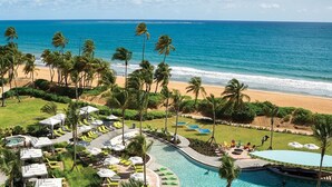 A resort with a pool, lounge chairs, and a view of the beach and ocean. - Ocean & Mountain Views and Exclusive Beach Access in a Tropical Studio Suite (Rio Grande)