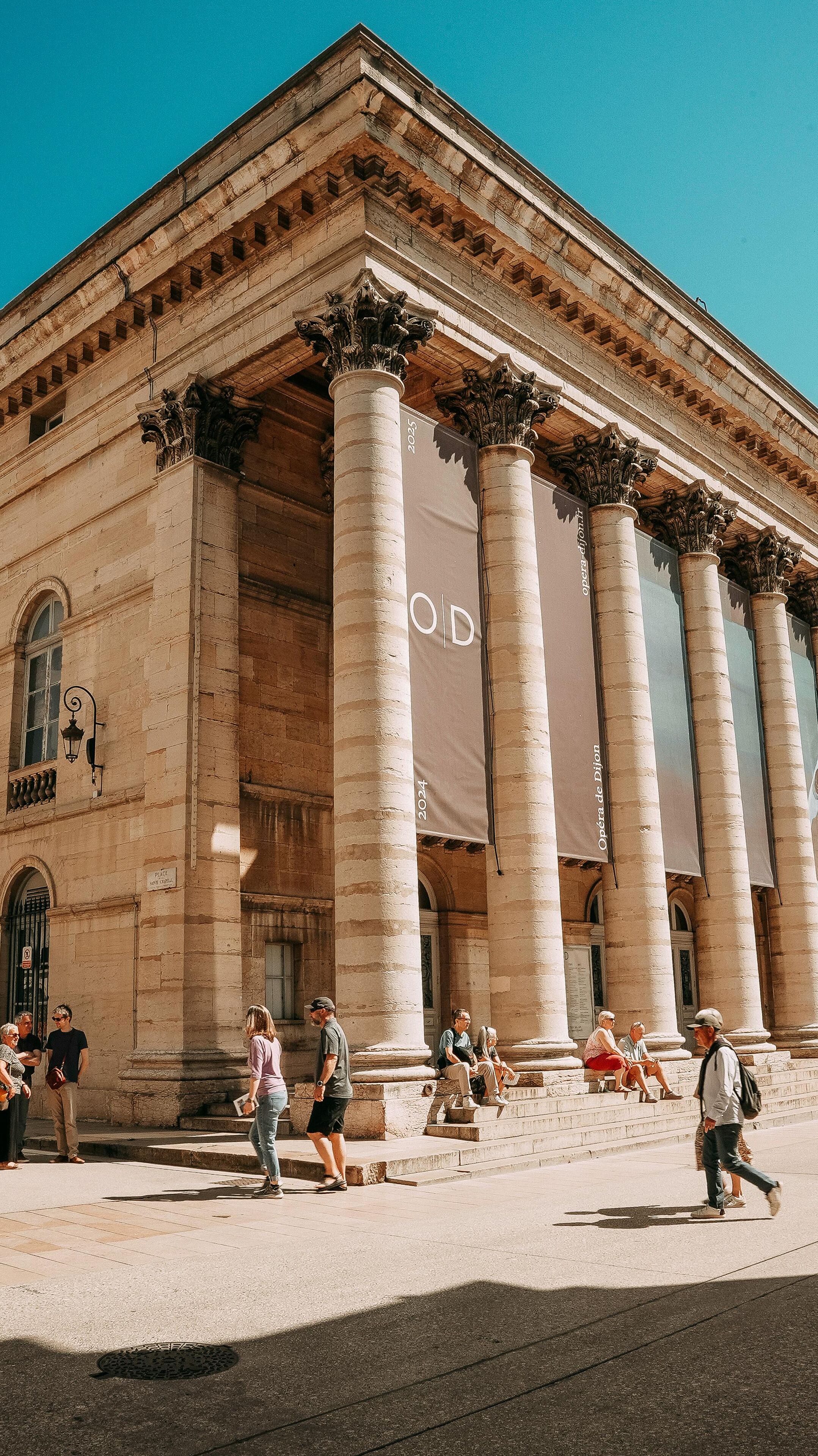 Un edificio clásico con grandes columnas y un cartel llamativo.