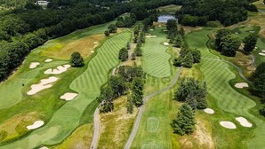 An aerial view of a golf course with sand bunkers, trees, and a pond. - Cozy Ludlow, Vermont Farmhouse Ski Retreat with hot tub and fire pit (Ludlow)