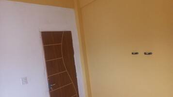 A room with a door, a light switch, and a wall socket.