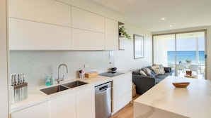 A modern kitchen with a built-in dishwasher, a large island, and a view of the sea. - Breathtaking View! (Point Lookout)