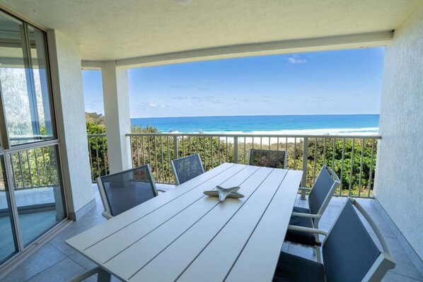 A balcony with a white table and chairs, overlooking a beach and ocean. - Breathtaking View! (Point Lookout)