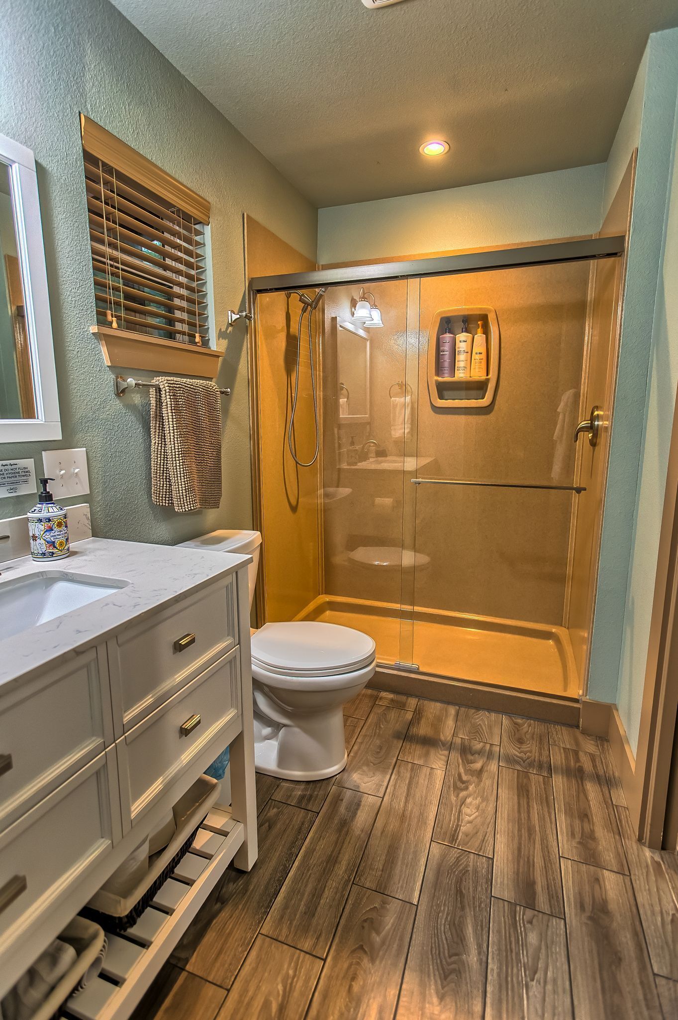 Une salle de bain équipée d’une douche, de toilettes et d’un meuble-lavabo.