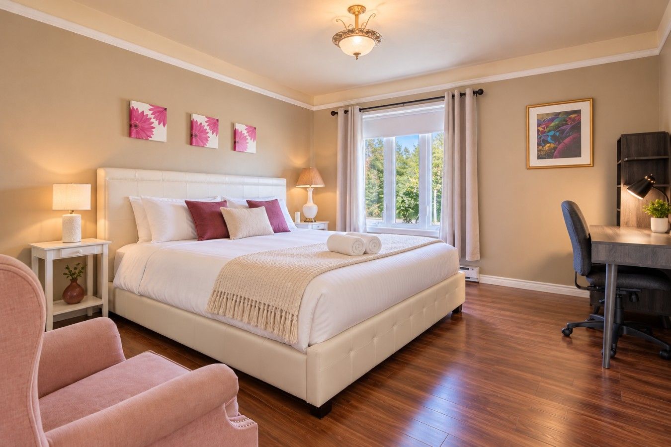 Quarto com cama grande, mesas de cabeceira, escrivaninha e uma cadeira.