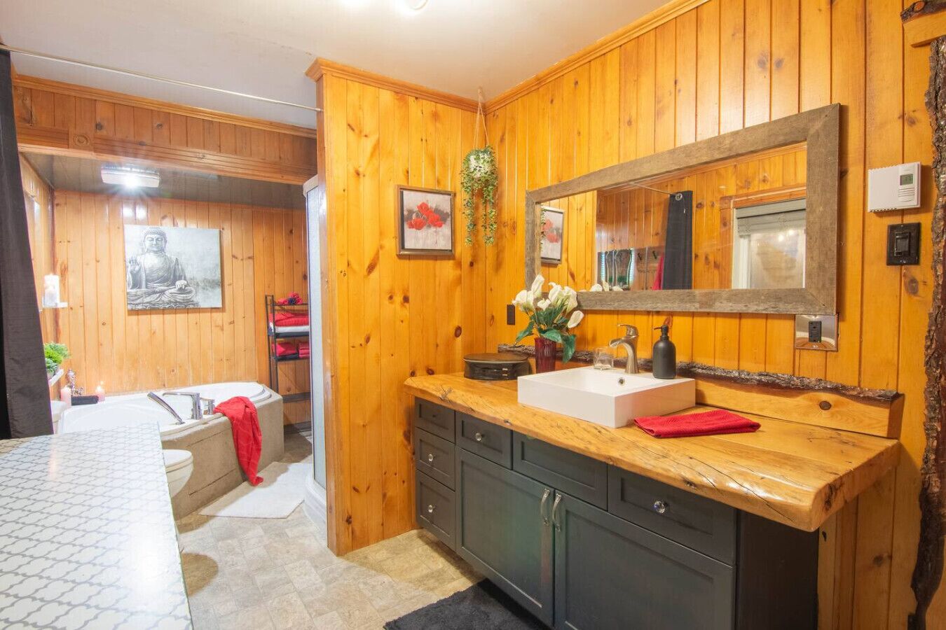 A wooden cabin bathroom with a bathtub, a sink, and a mirror.