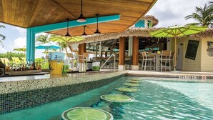 A poolside bar area with a bar counter, umbrellas, and a pool with lime slices. - Wyndham-Rio Mar Rio Grande 1BD/BA Presidential Ocean View Exclusive Beach Access (Rio Grande)
