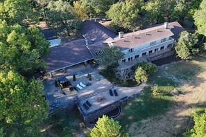 An aerial view of a large house with a spacious patio, multiple windows, and a well-maintained lawn. - Campfire Ranch Little Sugar (Bella Vista)