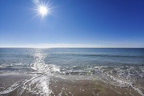 A beach with clear blue water and a bright sun in the sky. - Phoenix 2 - 2044 | Beachfront | Outdoor & Indoor Pool | Tennis (Orange Beach)