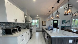 A modern kitchen with white cabinets, a marble island, and pendant lighting. - Escape to Country Comfort

Perfect for a romantic escape, or family retreat. (Iroquois)